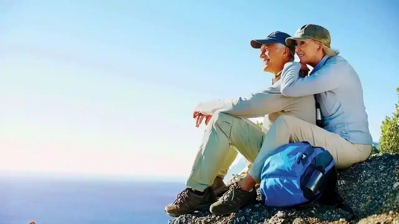 couple sitting on mountainside relaxing after making stnl property investments